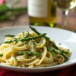 Rezeptidee Wein zum Essen Linguine mit grünem Spargel auf weißem Teller und einem Glas Verdicchio