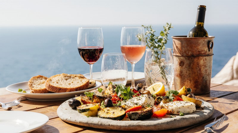 Rezeptidee Wein zum Essen Mediterraner Halloumi Gemüse Grillteller mit Zitrone einem Glas Rosé und einem Glas Rotwein
