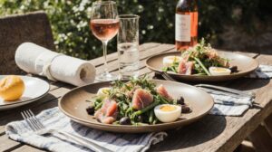 Rezeptidee Wein zum Essen Frisch zubereiteter Salade Niçoise mit Thunfisch, Bohnen, Oliven und Eiern, serviert mit Rosé de Provence im Garten
