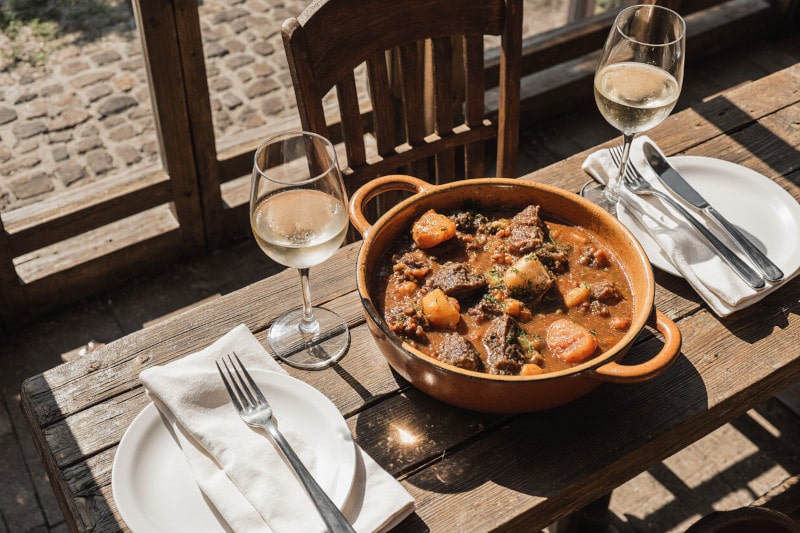 Wein zum Essen Baeckeoffe mit Fleisch, Kartoffeln, Gemüse & Pinot Gris d’Alsace im elsässischen Stil