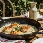 Wein zum Essen Coq au Riesling mit goldbraunem Hähnchen, cremiger Rieslingsauce & Riesling d’Alsace auf französischem Terrassentisch