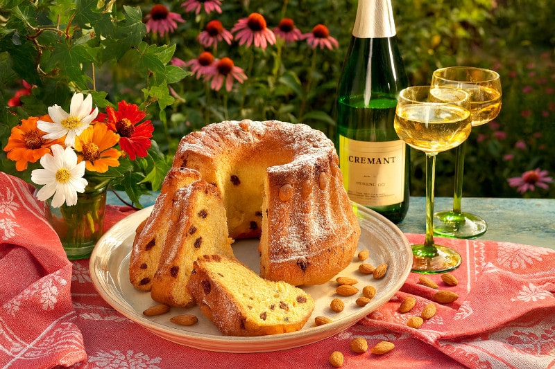 Wein zum Essen Kougelhopf mit Mandeln, Rosinen & Muscat d’Alsace/Crémant d’Alsace auf französischem Gartentisch