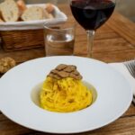 Wein zum Essen Tajarin al Tartufo mit Barbaresco, piemontesischer Restauranttisch