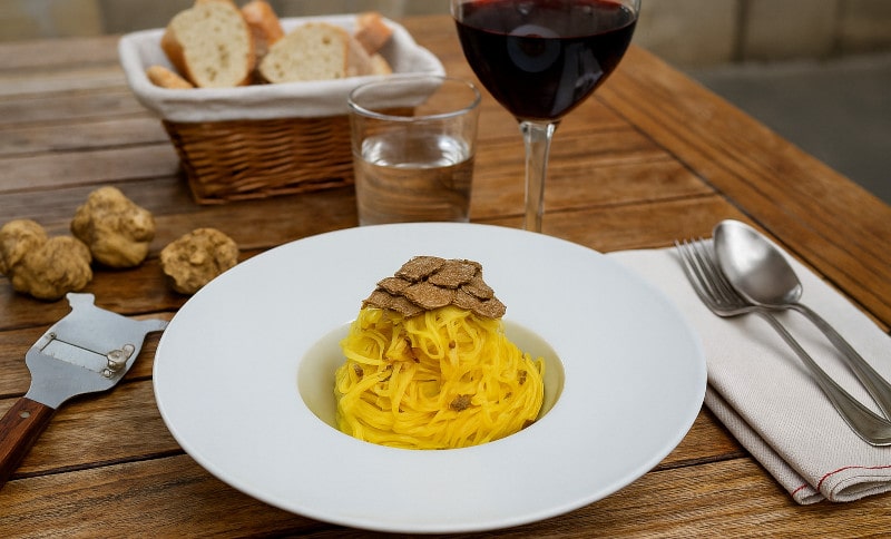 Wein zum Essen Tajarin al Tartufo mit Barbaresco, piemontesischer Restauranttisch
