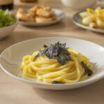 Wein zum Essen Pasta al Tartufo Nero mit Tagliolini, schwarzem Trüffel und Butter, serviert mit einem Glas Chardonnay aus Puligny-Montrachet
