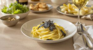 Wein zum Essen Pasta al Tartufo Nero mit Tagliolini, schwarzem Trüffel und Butter, serviert mit einem Glas Chardonnay aus Puligny-Montrachet