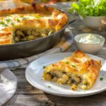 Wein zum Essen Pilz-Strudel mit Lauch und Kräuterrahm, serviert mit einem Glas Grüner Veltliner aus dem Kamptal, Österreich