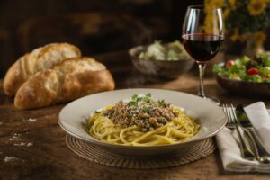 Wein zum Essen – Linsen-Pilz-Bolognese mit Kräutern und Pecorino auf rustikalem Holztisch mit Chianti-Glas