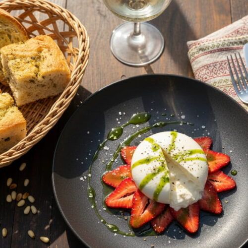 Wein zum Essen: Burrata auf marinierten Erdbeeren mit Basilikum-Öl und einem Glas Vermentino.